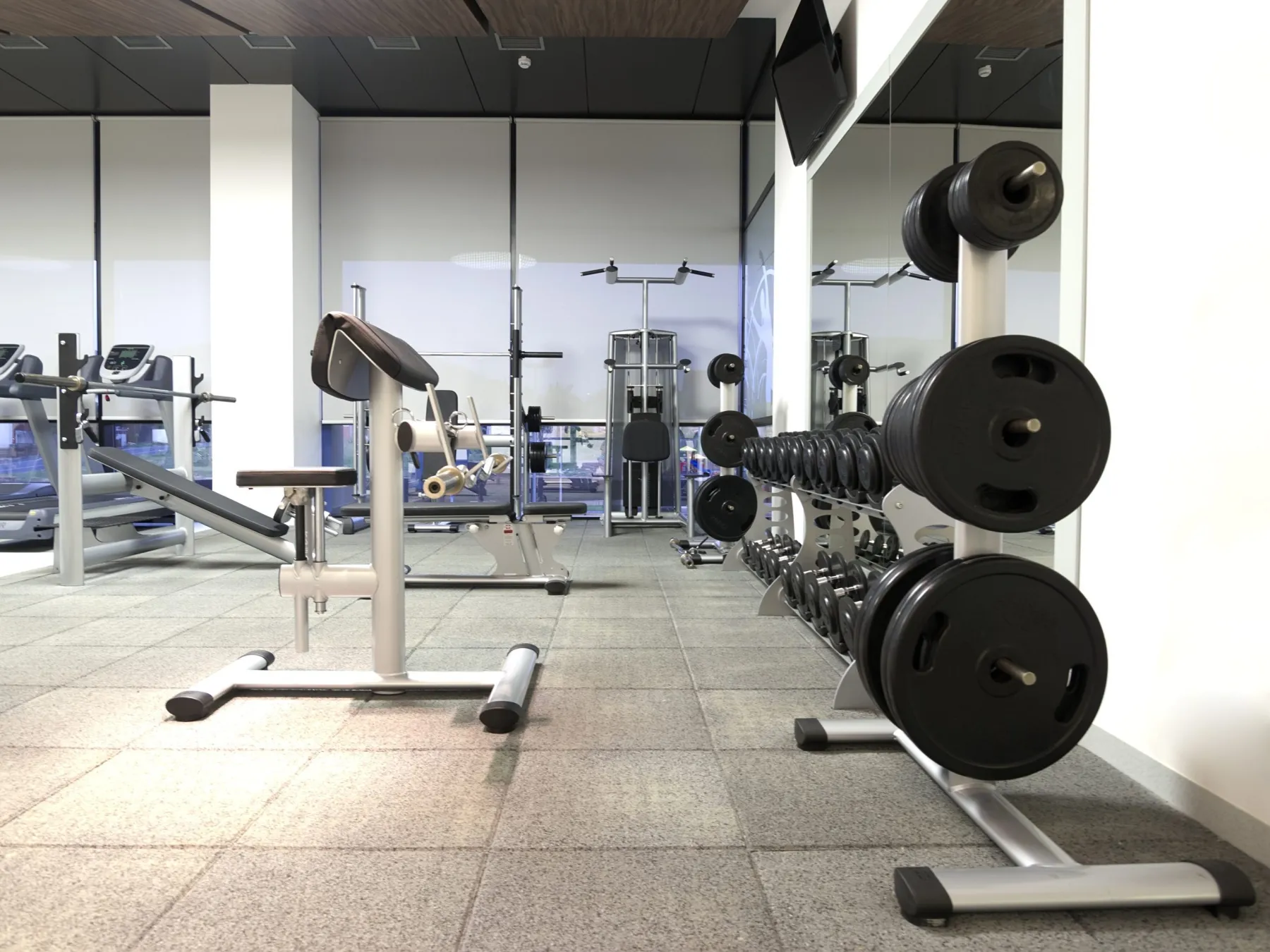 Home gym with mirror wall and rubber flooring in Dubai